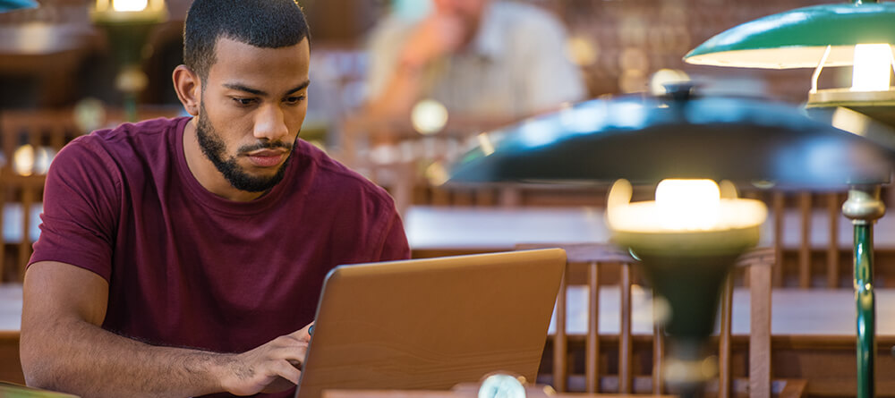Male pre-med student studying in library