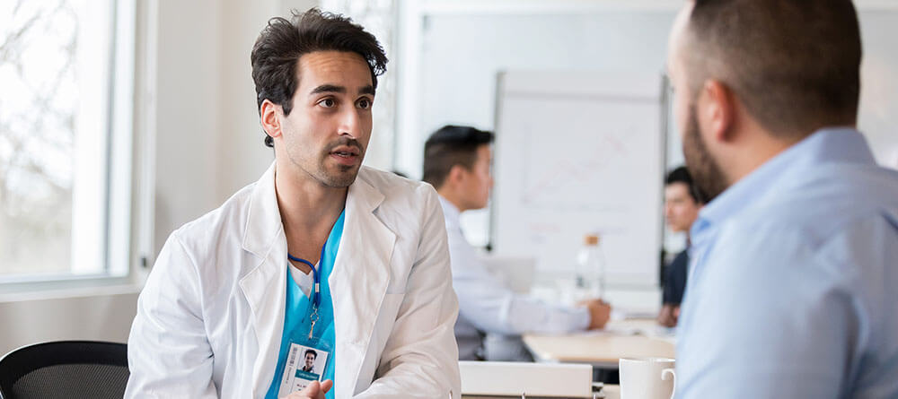 A doctor speaks with a medical student during a residency interview.