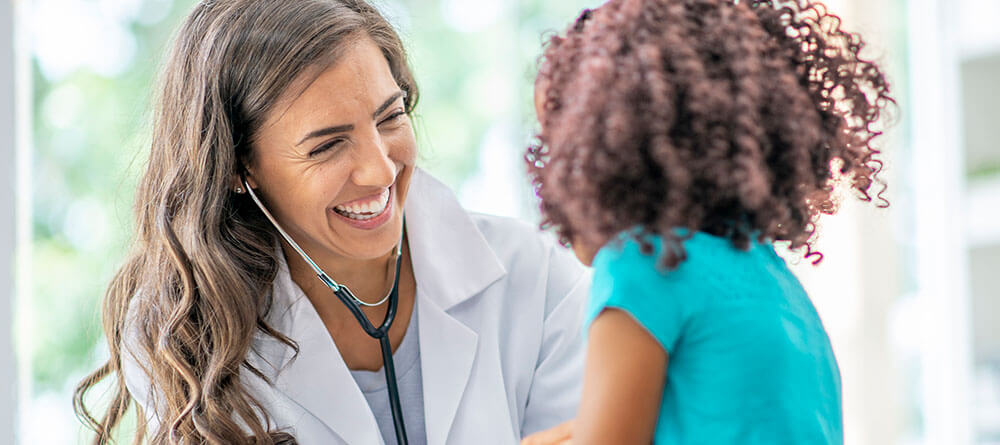 Female pediatrician takes vitals on adolescent female patient.