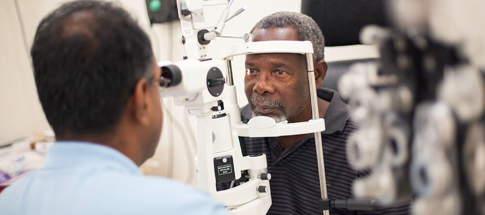 Dr. Bala Ambati performs eye exam on a patient at the SGU campus.