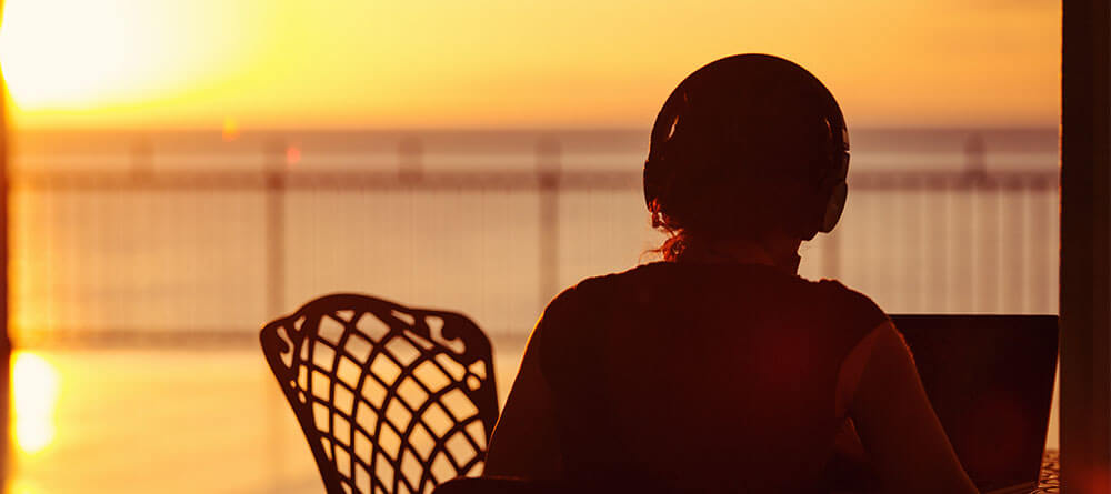 SGU student studying on balcony with sunset