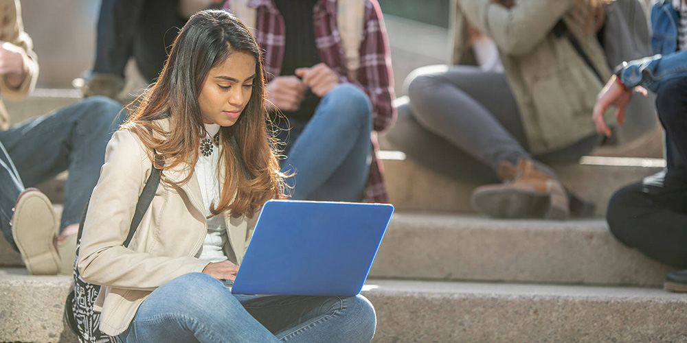 Undergraduate student studying on campus steps