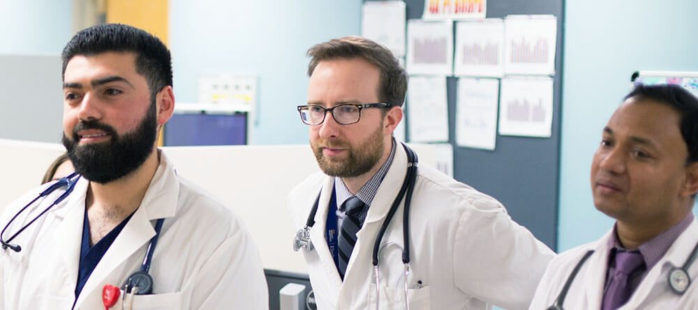 A group of physicians share a moment as they read an update.