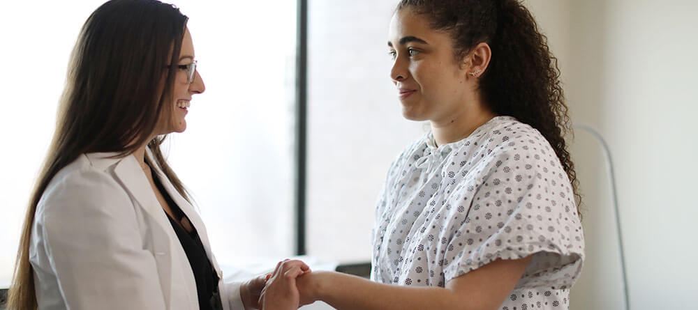 Physician speaking with patient in exam room