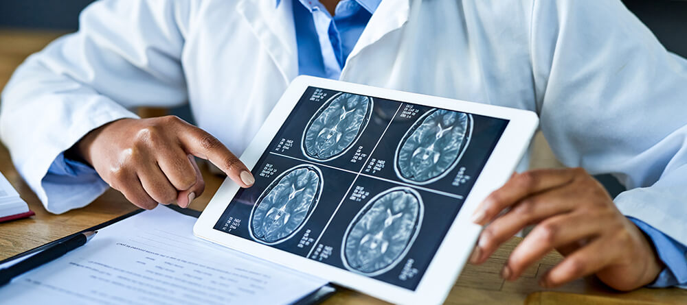 Close up of neurologist explaining results of brain scan to patient.