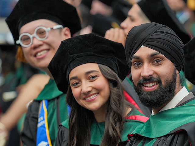 Three graduates at SOM Commencement